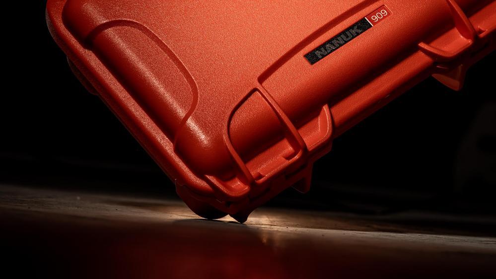 Red hard-shell case with 'Nanuk' branding on a dark background